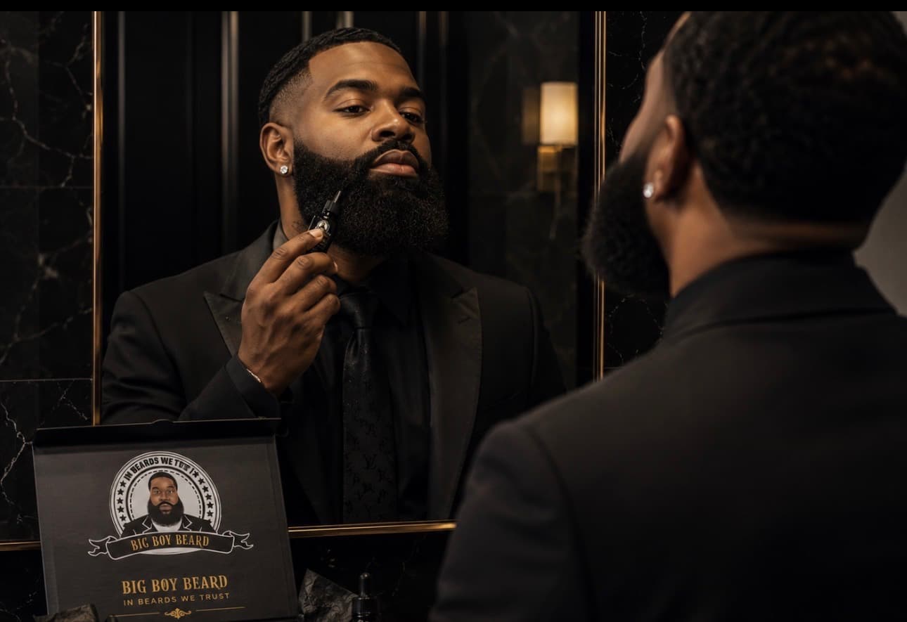 A gentleman applying Big Boy Beard oil in front of a black marble mirror